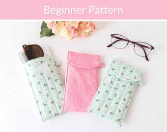 May include: Three rectangular fabric pouches for eyewear, including two light green cases with a small pink floral pattern and one solid pink case. The text "Beginner Pattern" is displayed at the top of the image above the pouches.