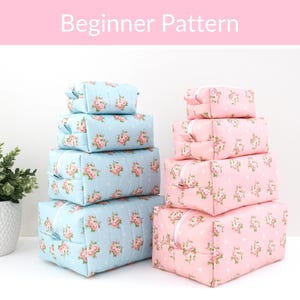 May include: Two stacks of four rectangular zippered pouches in varying sizes. The left stack is light blue with a pink floral and white polka dot pattern. The right stack is light pink with a matching floral and white polka dot pattern. Text reads Beginner Pattern.
