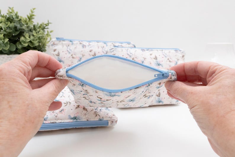 Beginner zip pouch held open to show the fully lined interior with no raw edges and a blue zip.