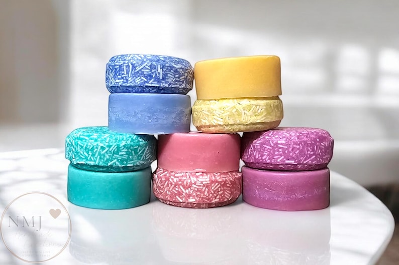 Five different colors of shampoo and conditioner bars stacked