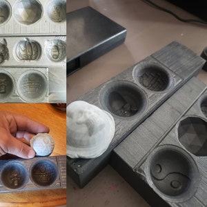 May include: Two grey wooden moulds with different designs for making round resin crafts. The moulds are stacked on top of each other. A white resin sphere is sitting on top of the moulds.