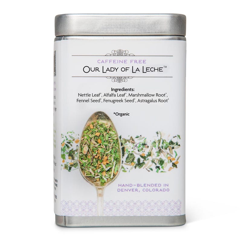 May include: A rectangular metal tin with a silver lid, labeled "CAFFEINE FREE OUR LADY OF LA LECHE." The front displays a spoon filled with green herbs and the ingredients: Nettle Leaf, Alfalfa Leaf, Marshmallow Root, Fennel Seed, Fenugreek Seed, and Astragalus Root. "HAND-BLENDED IN DENVER, COLORADO" is printed at the bottom.