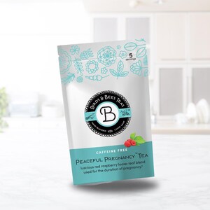 May include: A white tea bag with a teal and black logo that reads "Birds & Bees Teas". The bag has a teal band with the words "Peaceful Pregnancy Tea" and "Caffeine Free". The bag contains a red raspberry loose-leaf blend.