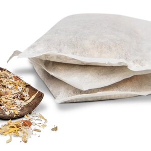 May include: A wooden scoop filled with dried herbs and flowers, with three white muslin bags of the same herbs and flowers stacked next to it.
