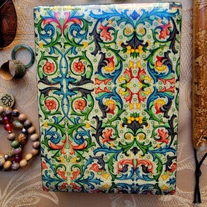 May include: A rectangular box featuring a dense, symmetrical pattern of scrolling acanthus leaves and floral motifs in vibrant shades of green, blue, red, and yellow against a pale cream background, with a glossy, smooth finish on the surface.