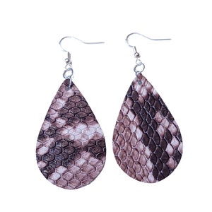 May include: A pair of dangle earrings with a teardrop-shaped design. The earrings are made of brown and white faux snakeskin material and have silver hooks.