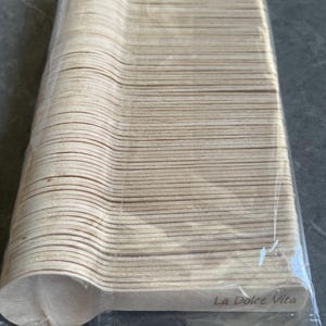 May include: A pack of disposable wooden spoons. The spoons are light brown and have a rounded bowl shape. The text "La Dolce Vita" is printed on the packaging.