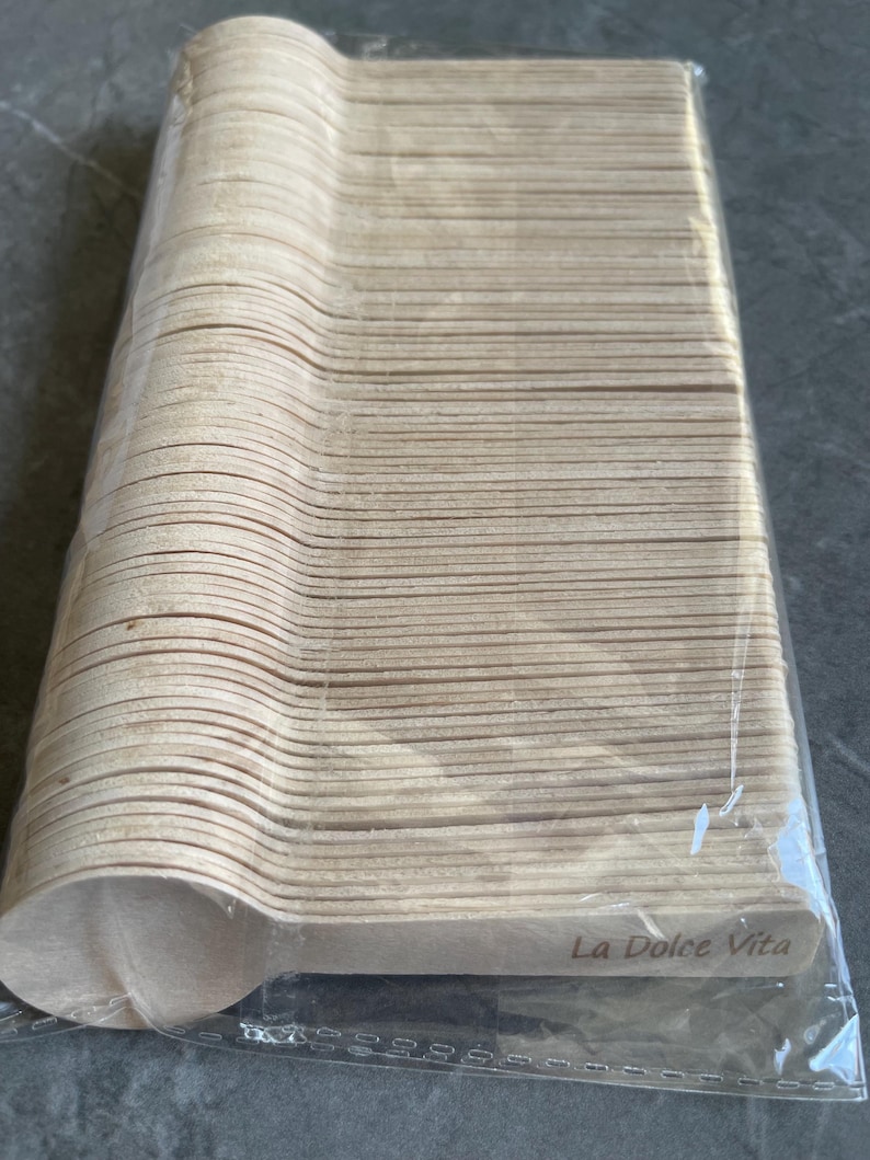 May include: A pack of disposable wooden spoons. The spoons are light brown and have a rounded bowl shape. The text "La Dolce Vita" is printed on the packaging.