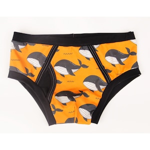 Men&#39;s cotton briefs. Whales on orange background