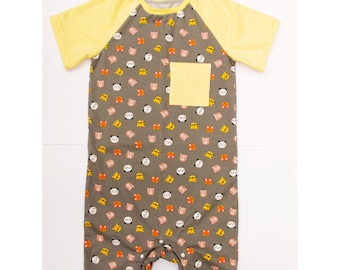 Macacão adulto com estampa de bebê, mangas raglan e abertura na parte inferior.