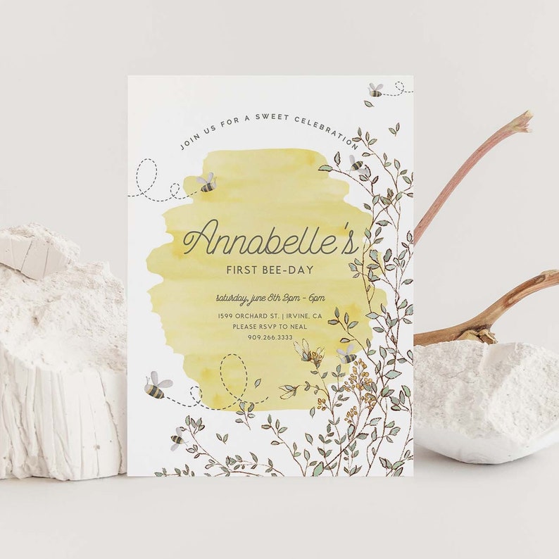 May include: A yellow and white invitation with a watercolor background and bees. The text reads "Join us for a sweet celebration, Annabelle's First Bee-Day, Saturday, June 8th 2pm - 6pm, 1599 Orchard St. | Irvine, CA, Please RSVP to Neal, 909.266.3333".