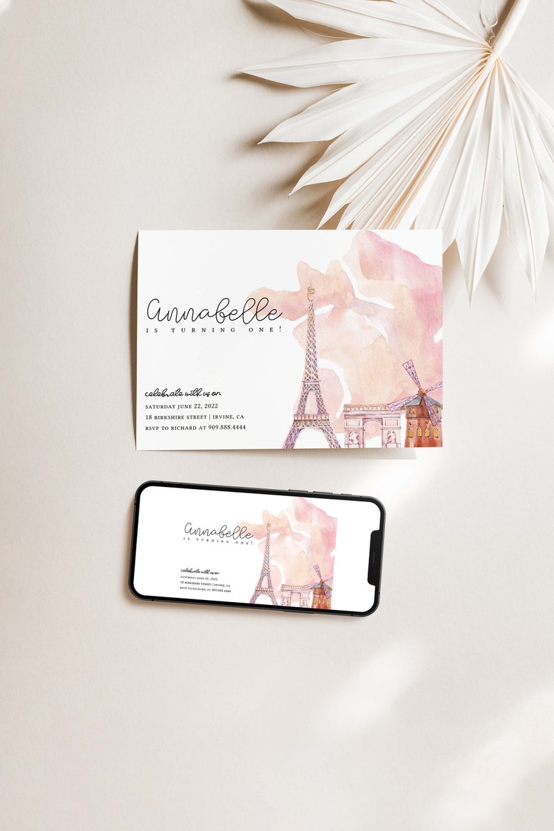 May include: A pink and white watercolor invitation with a drawing of the Eiffel Tower, Arc de Triomphe, and a windmill. The text on the invitation reads "Annabelle is turning one!" and includes details for a party on June 22, 2022, at 15 Berkshire Street, Irvine, CA. RSVP to Richard at 909.888.4444.