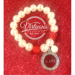 Delta Sigma Theta Pearl charm bracelet with red rhinestone beads.