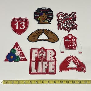 May include: Collection of embroidered patches in various shapes and designs. Includes a red and white patch with the number 13, a patch with the text "Black Girl Magic", and a patch with the text "FOR LIFE".