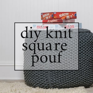 May include: A gray and white knitted square pouf with the text "diy knit square pouf" in black letters. The pouf is sitting on a white rug in front of a white wall. There are board games stacked on top of the pouf.