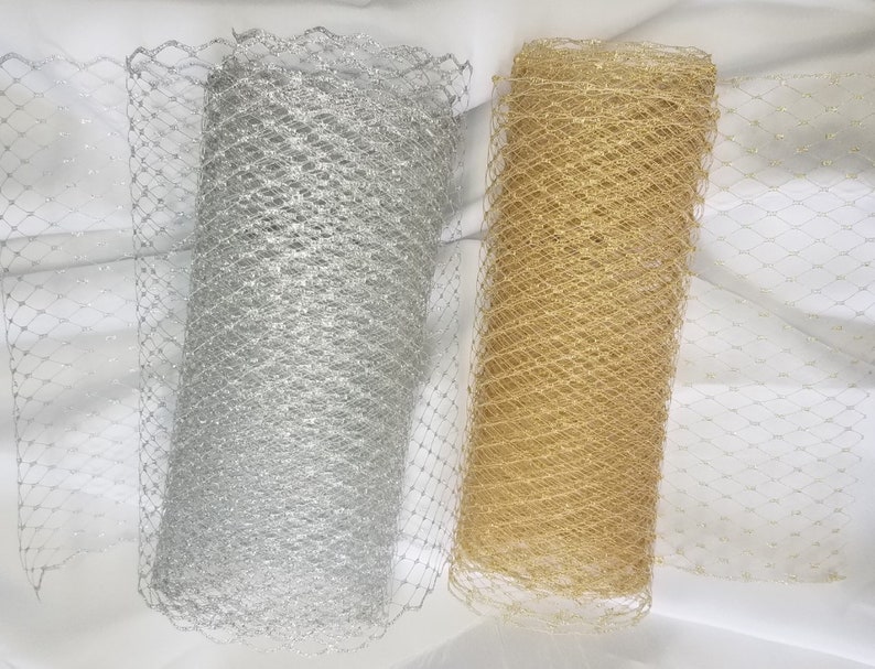 Puede incluir: Dos rollos de tejido de red, uno plateado y otro dorado. La red es una malla fina con un acabado brillante.