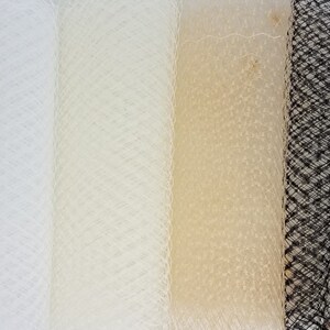 May include: Four rolls of netting fabric in white, ivory, and black. The netting is a fine mesh with a diamond pattern.