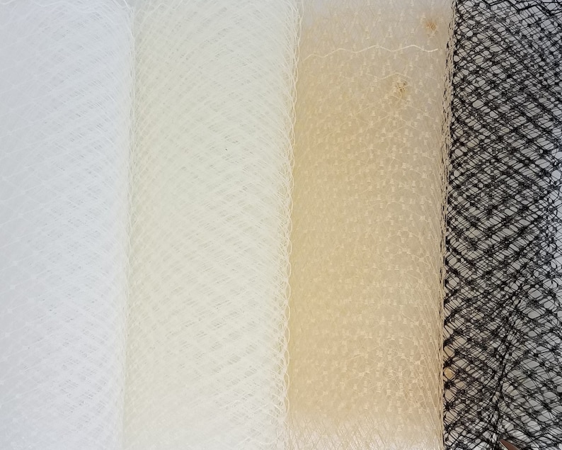 May include: Four rolls of netting fabric in white, ivory, and black. The netting is a fine mesh with a diamond pattern.