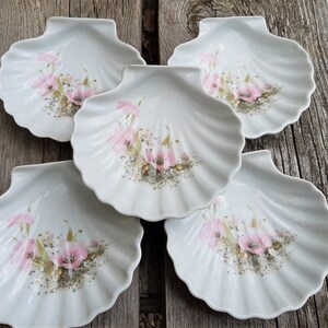 Peut inclure: Ensemble de cinq plats en porcelaine blanche en forme de coquille avec des motifs floraux roses.