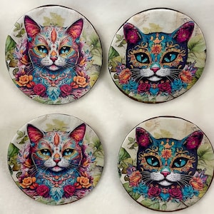 May include: Four round coasters with a colorful floral design and a black and white cat with a sugar skull design. The coasters are made of a hard material and have a glossy finish.
