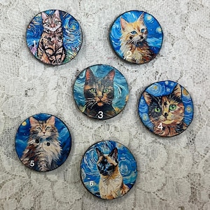 May include: Set of six round cat-themed decorative buttons. Each button features a different cat portrait against a swirling blue and yellow background, reminiscent of a starry night. The cats have various fur colors and patterns, with numbers 1 through 6.