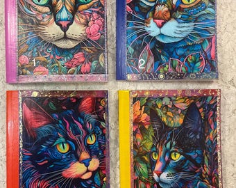 Puede incluir: Cuatro cuadernos coloridos con diferentes diseños de gatos. Cada cuaderno tiene un número en la portada, del 1 al 4. Los gatos están todos estilizados y tienen colores y patrones brillantes.