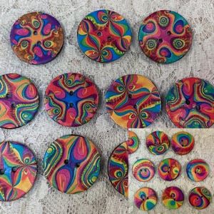 May include: Assortment of colorful, round, wooden buttons with a psychedelic swirl pattern. The buttons have two holes and are approximately 1 inch in diameter.