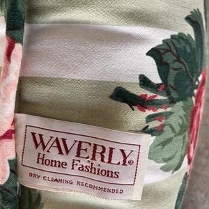 Puede incluir: Una tela de rayas blancas y verdes con un patr&oacute;n floral. La tela tiene una etiqueta que dice "Waverly Home Fashions" y "Se recomienda limpieza en seco".