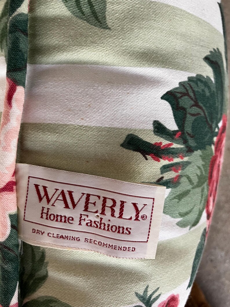 Puede incluir: Una tela de rayas blancas y verdes con un patr&oacute;n floral. La tela tiene una etiqueta que dice "Waverly Home Fashions" y "Se recomienda limpieza en seco".