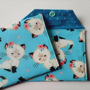 Lindos gatos blancos sobre una mini billetera azul