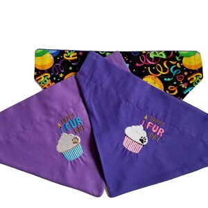 May include: Two purple dog bandanas with a cupcake design and the text "Happy Fur Day". The bandanas are reversible with a black background with colorful confetti and the text "Happy Birthday".