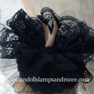 Powder Puff Black con patas de porcelana con zapato negro con encaje de volantes y tul