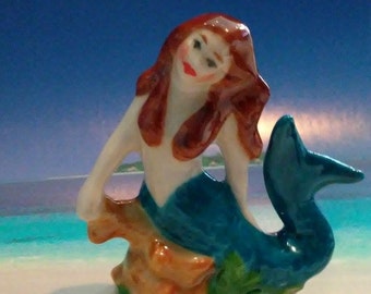 Mermaid Figurine Porcelain in Turquoise sitting in ocean grass and coral