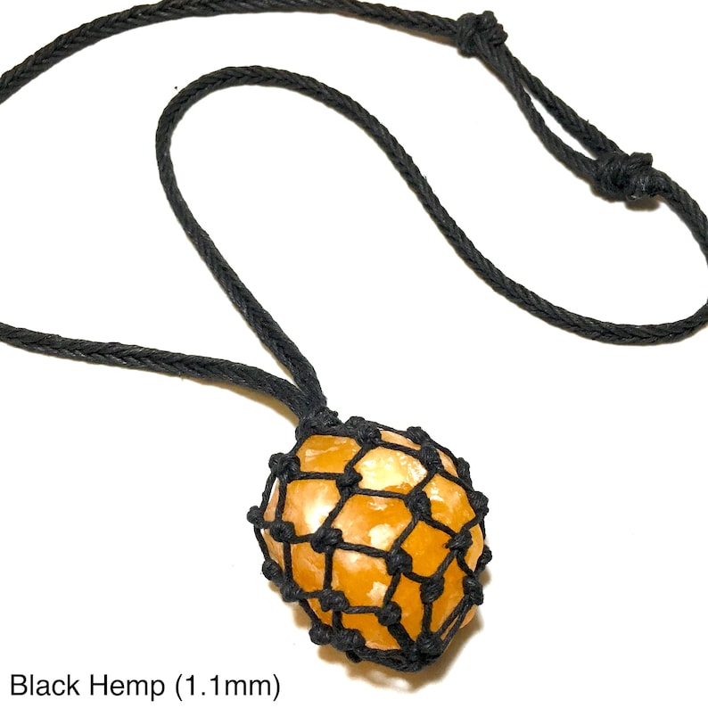 May include: A necklace featuring a spherical, orange-colored stone encased in a black woven net, suspended from a black hemp cord. The text "Black Hemp (1.1mm)" is visible at the bottom of the image.