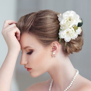 Beautiful bride wearing custom silk Gardenia Wedding headpiece by Malama Pua Bridal.  This hair accessory is a traditional classic Bridal Gardenia hair clip and is created with hand wired crystal center and completed with tropical green leaves.