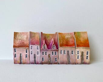 A set of five rustic soft pink shaded houses  in a row