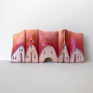 A set of five rustic pastel pink shaded houses  in a row