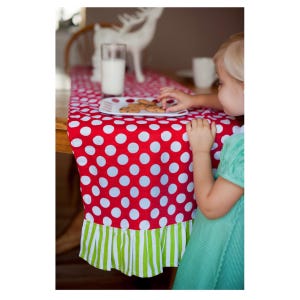 Red and white polka dot table runner with a green and white striped ruffle trim