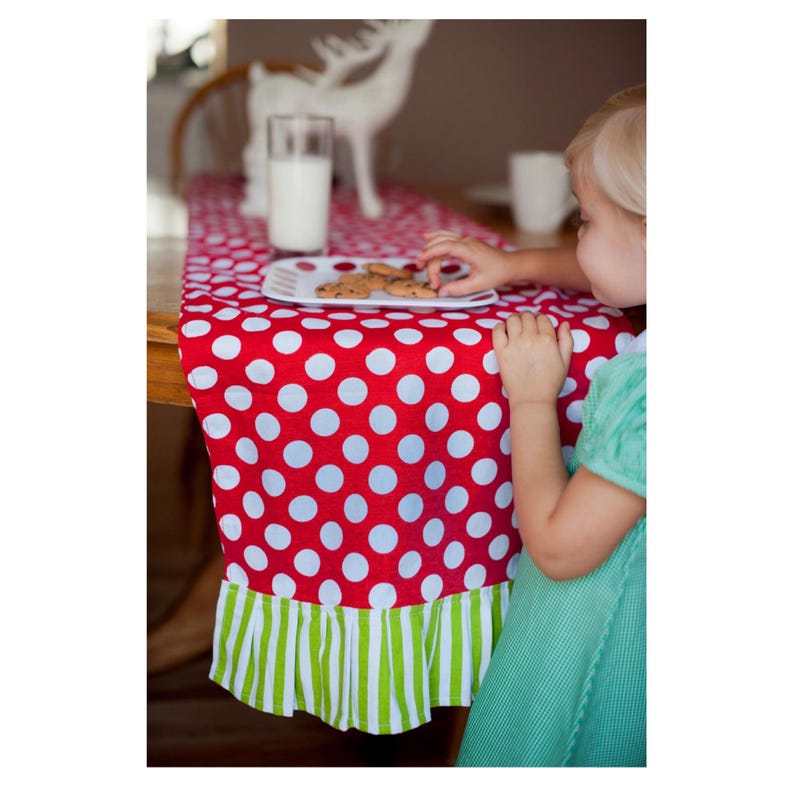 Red and white polka dot table runner with a green and white striped ruffle trim