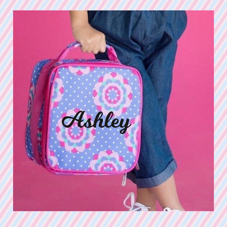 pink lunch bag with a purple and white floral pattern and white polka dots. The lunch bag has a zipper closure and a handle. The name is embroidered on the front