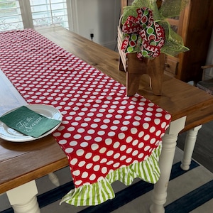 Whimsical Christmas Table Runner Red and white polka dot table runner with a green and white striped ruffle trim