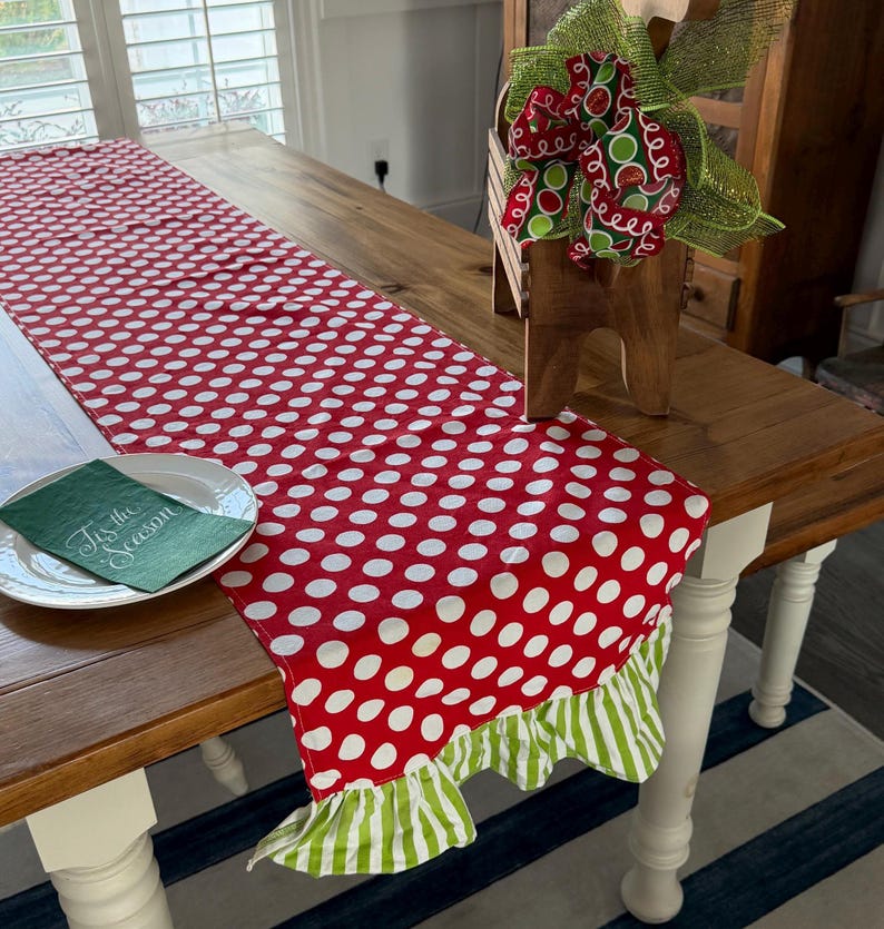 Whimsical Christmas Table Runner Red and white polka dot table runner with a green and white striped ruffle trim
