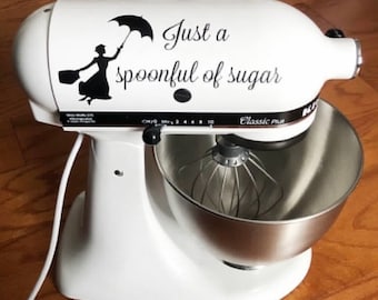 Puede incluir: Batidora de pie blanca con un tazón plateado y una calcomanía en blanco y negro que dice "Just a spoonful of sugar".