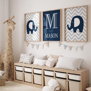 May include: Three framed prints with a blue and white chevron pattern. The center print features a large letter "M" in white with the text "M is for MASON" below. The other two prints feature a blue elephant silhouette.