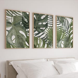 May include: Three framed prints with a tropical theme. The prints feature watercolor illustrations of green leaves on a white background.