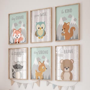 May include: Set of six framed prints featuring woodland animals and inspirational messages. The prints are in a light blue and gray color scheme with white text. The messages include "stay clever", "grow wise", "be kind", "be curious", "stay strong", and "be brave".