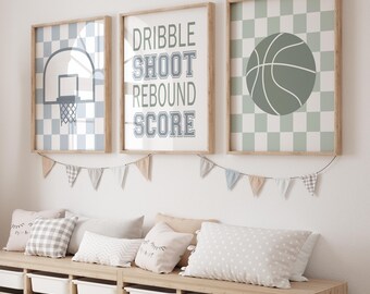 May include: Three framed prints with a basketball theme. The first print has a checkered background with a basketball hoop in the center. The second print has a green and white checkered background with a basketball in the center. The third print has a white background with the words "DRIBBLE SHOOT REBOUND SCORE" in black.
