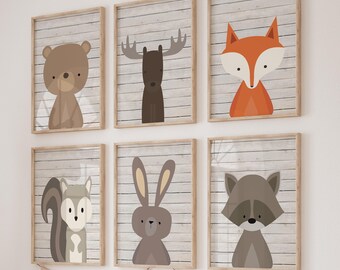 May include: Set of six framed animal prints with a woodgrain background. The animals are a bear, moose, fox, rabbit, squirrel, and raccoon. Each print features a different animal in a simple, cartoon style.