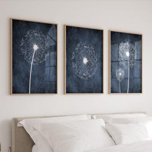 May include: Three framed prints with a blue background and white dandelion illustrations. The dandelions are in various stages of bloom.
