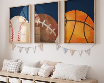 May include: Three framed prints of sports balls on a navy blue background. The balls are a baseball, a football, and a basketball. The frames are wood and have a light brown finish.